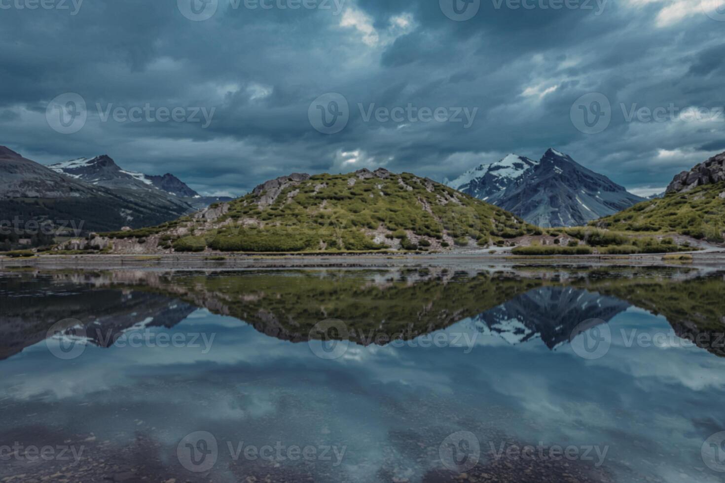 A photograph of a serene calm lake reflecting snow-capped mountain peaks photo