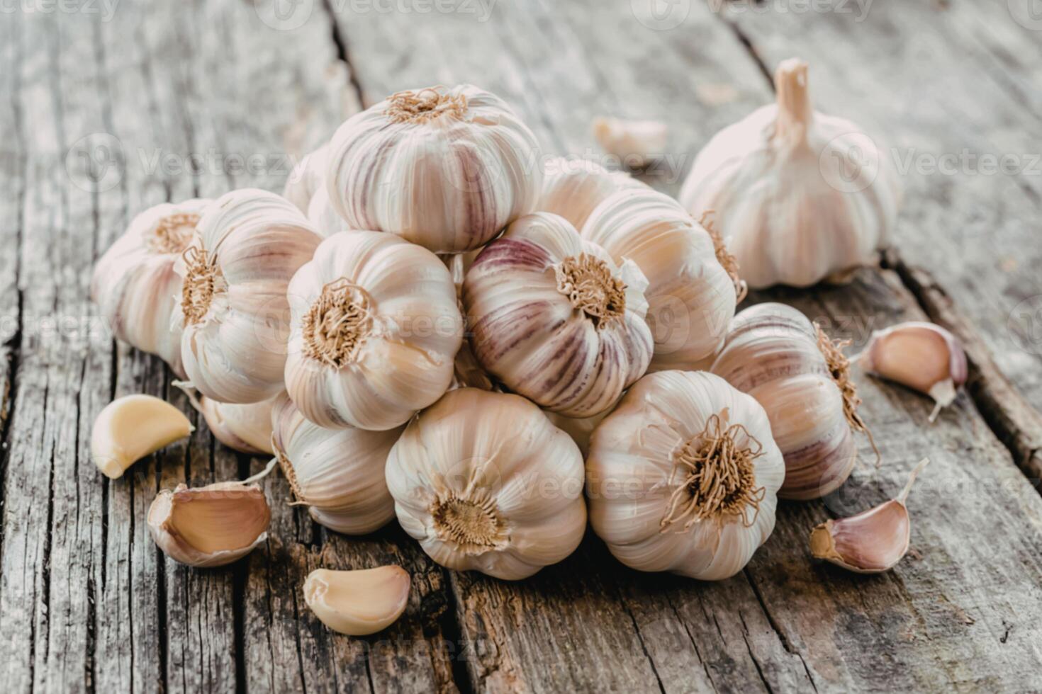 Fresh bulbs of garlic stacked on wooden gray background photo