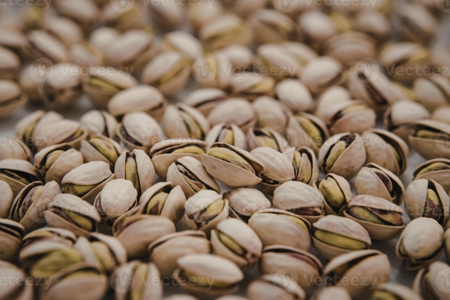 A photo of a pile of pistachios, with the majority still in their shells