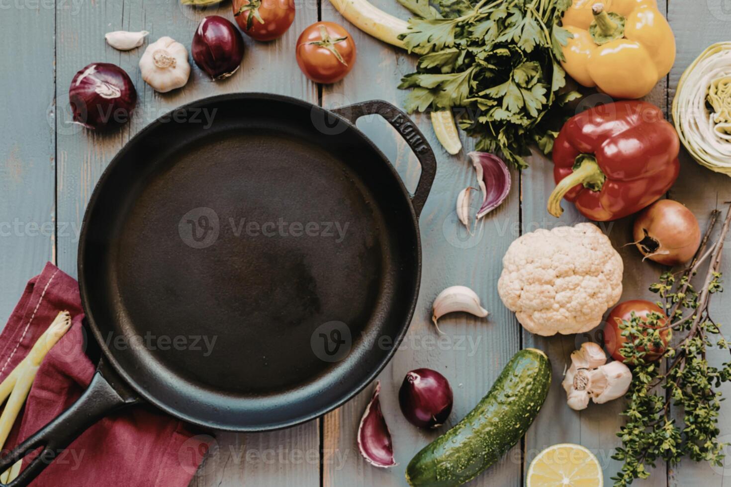 A pan with vegetables and other ingredients on a wooden table photo