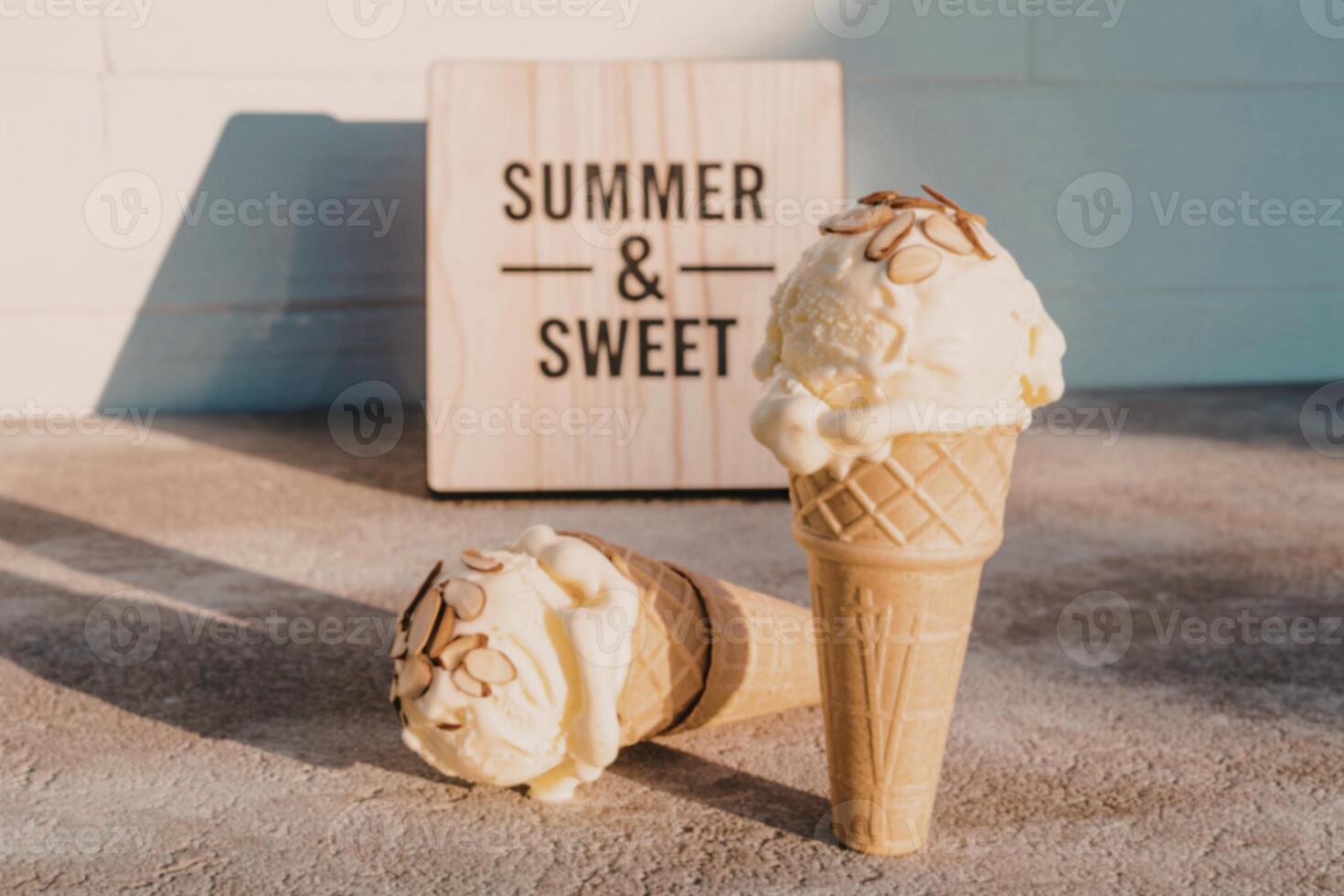 Two ice cream cones with a sign that says summer and sweet photo