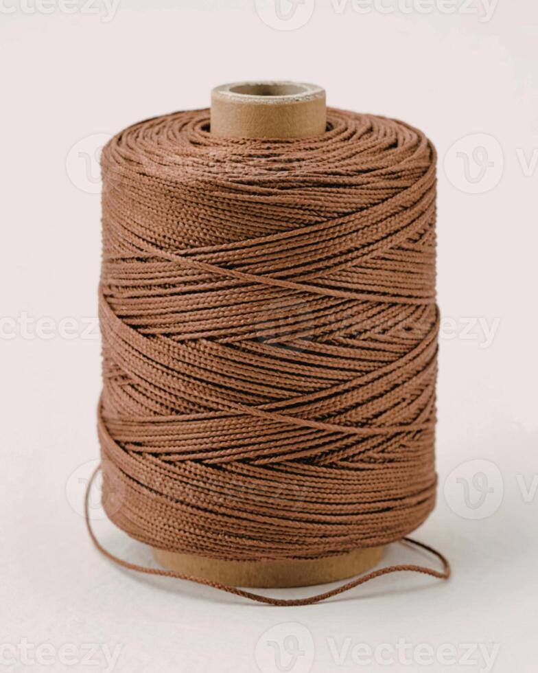 Brown thread spool on white isolated background, packaging rope photo