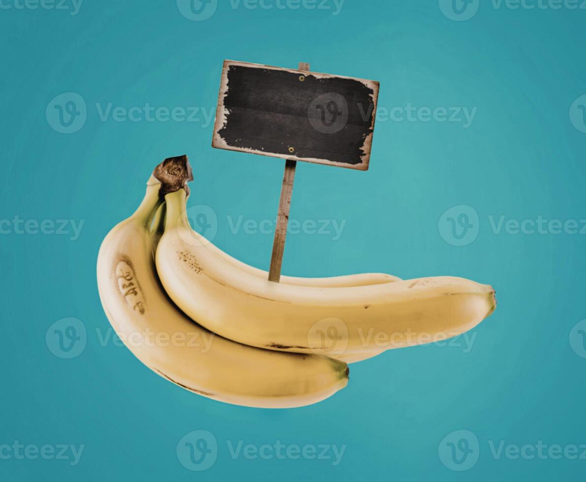 bunch of ripe yellow bananas and wooden signpost with empty black space, blue background photo