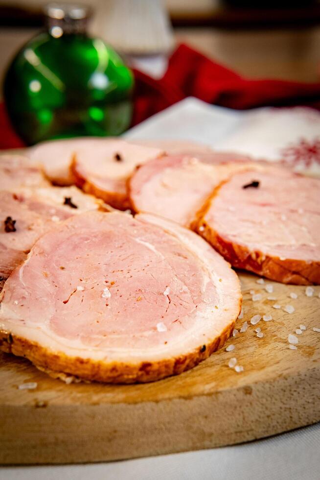 Pork leg pernil on a wooden board with Christmas themed decorations. photo