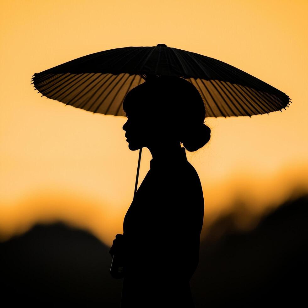 Silhouette of a woman holding a parasol against a sunset backdrop. Golden hour and shadow play concept. photo