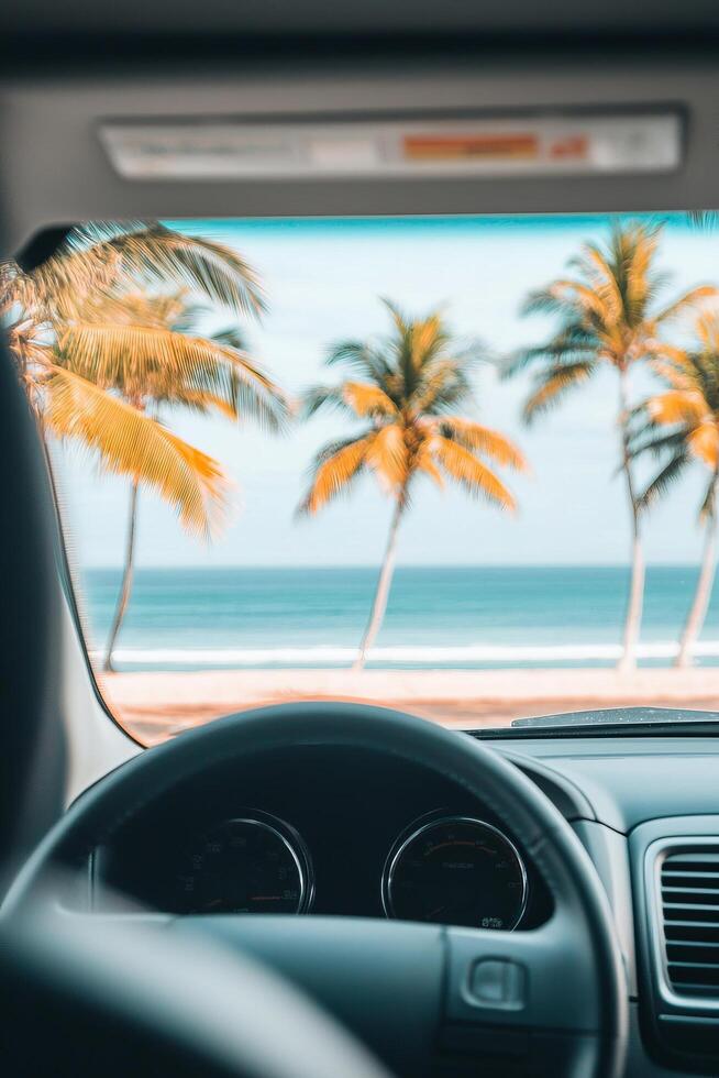 Summer break beach road trip concept. Scenic view of palm trees and ocean seen from a car interior. photo