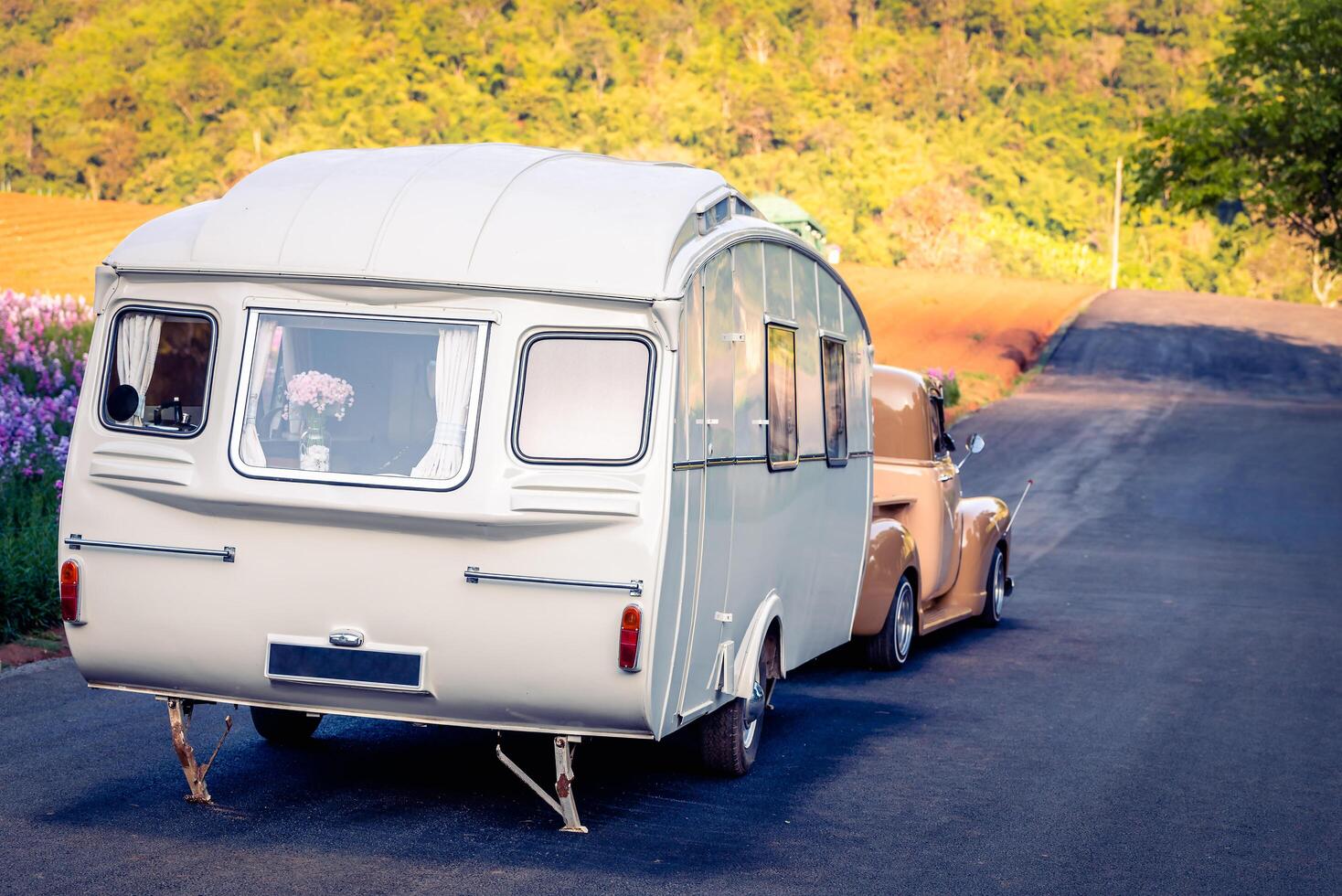 Retro classic caravan or recreational vehicle motor home trailer parked at parking area, vintage colour image. photo