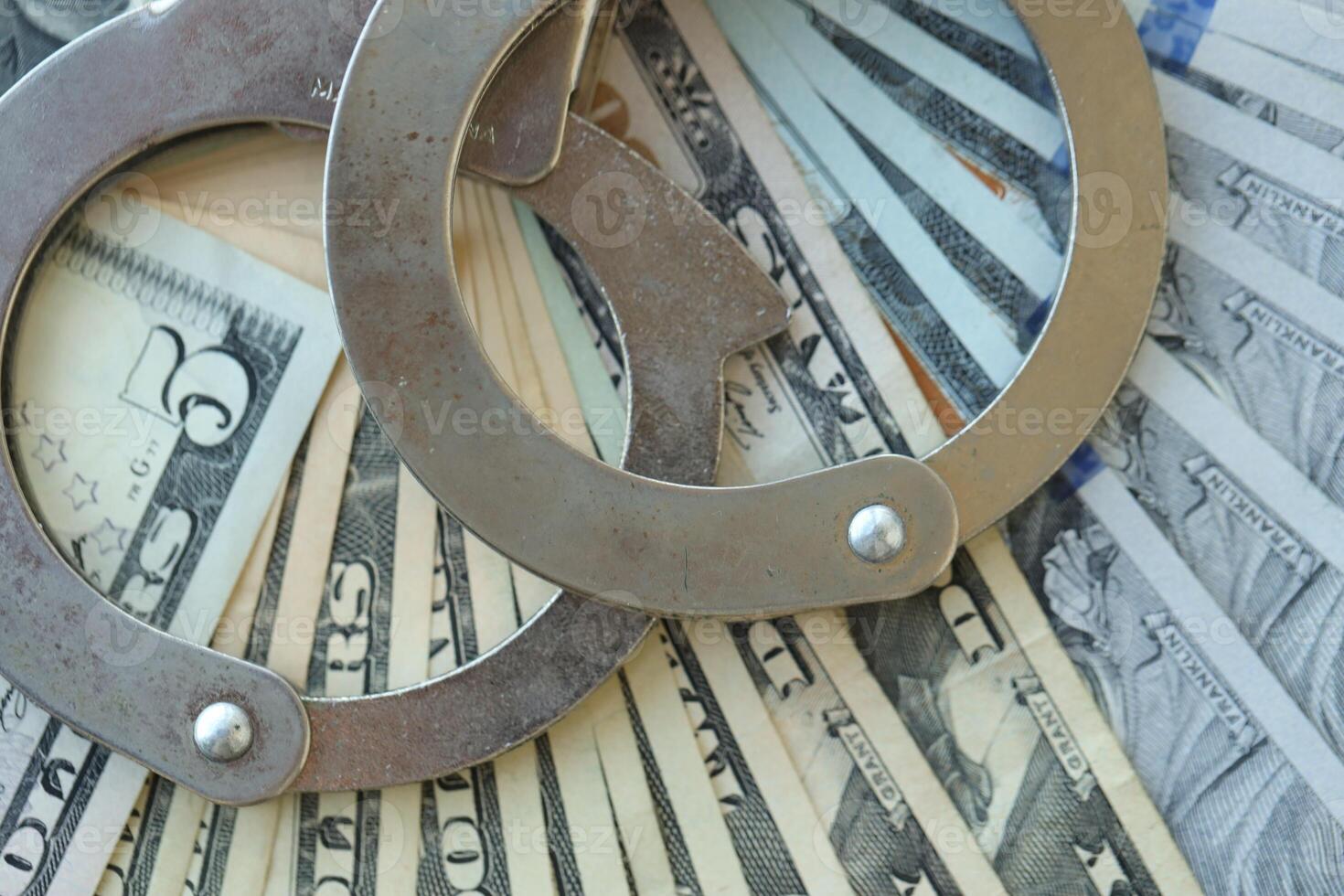 Handcuffs and a lot of dollars scattered on the table photo