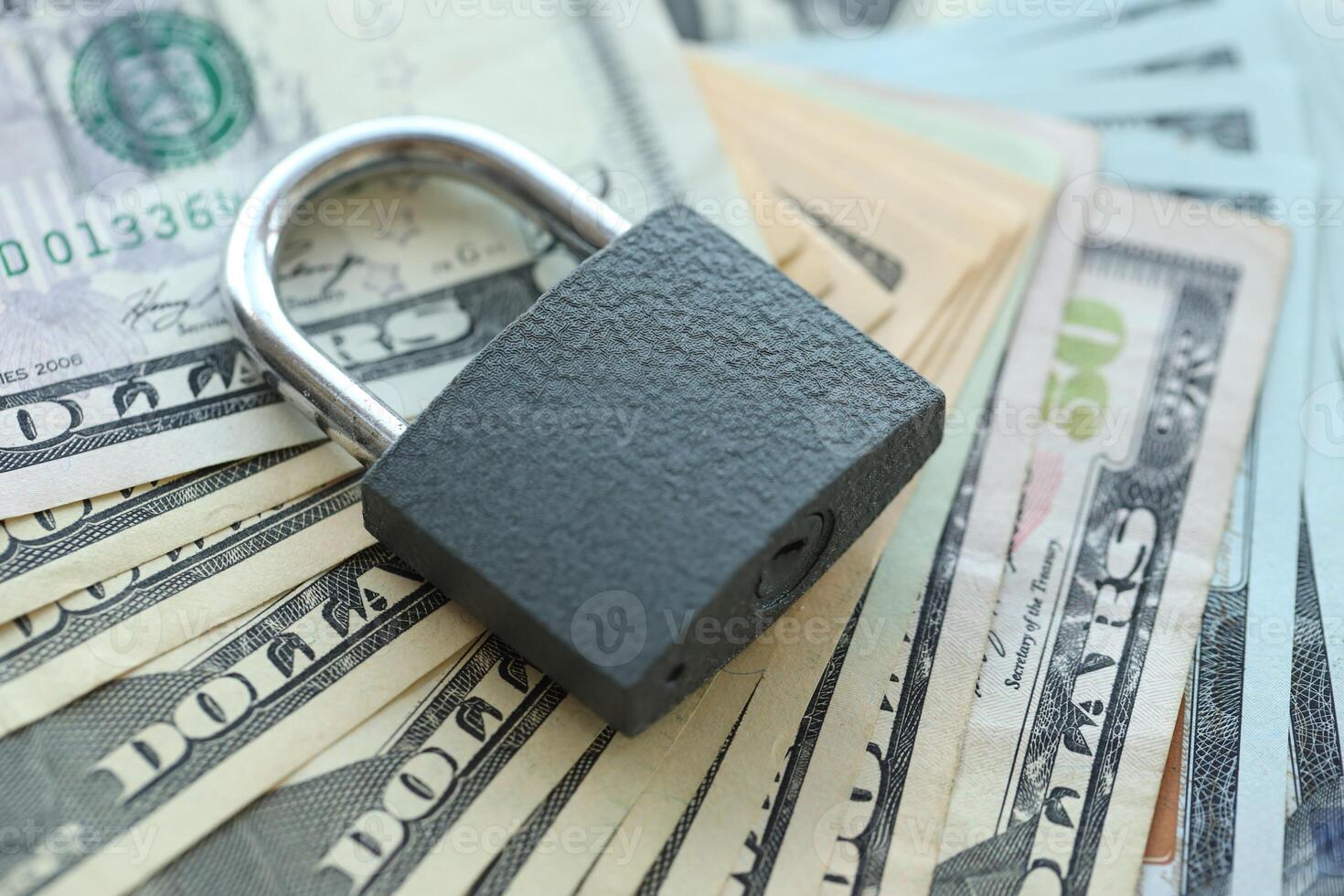 USD Dollar bills and a closed lock as a concept for imposing economic sanctions. photo