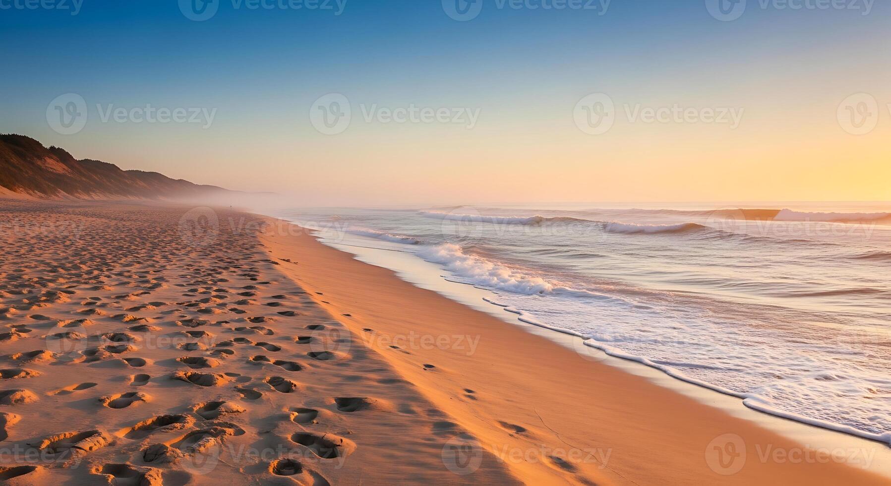 Serene Coastal Morning Beach Scene With Gentle Waves and Footprints In The Sand During Sunrise photo