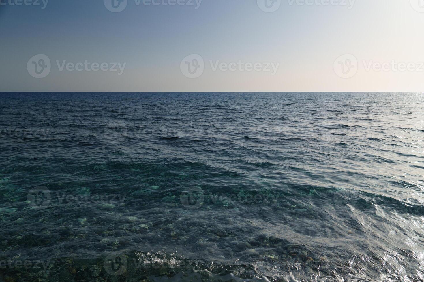 Experience the calming essence of the sea with this stunning image of turquoise waters meeting a pale blue sky. Ideal for travel and relaxation themes, evoking peace and escape. photo
