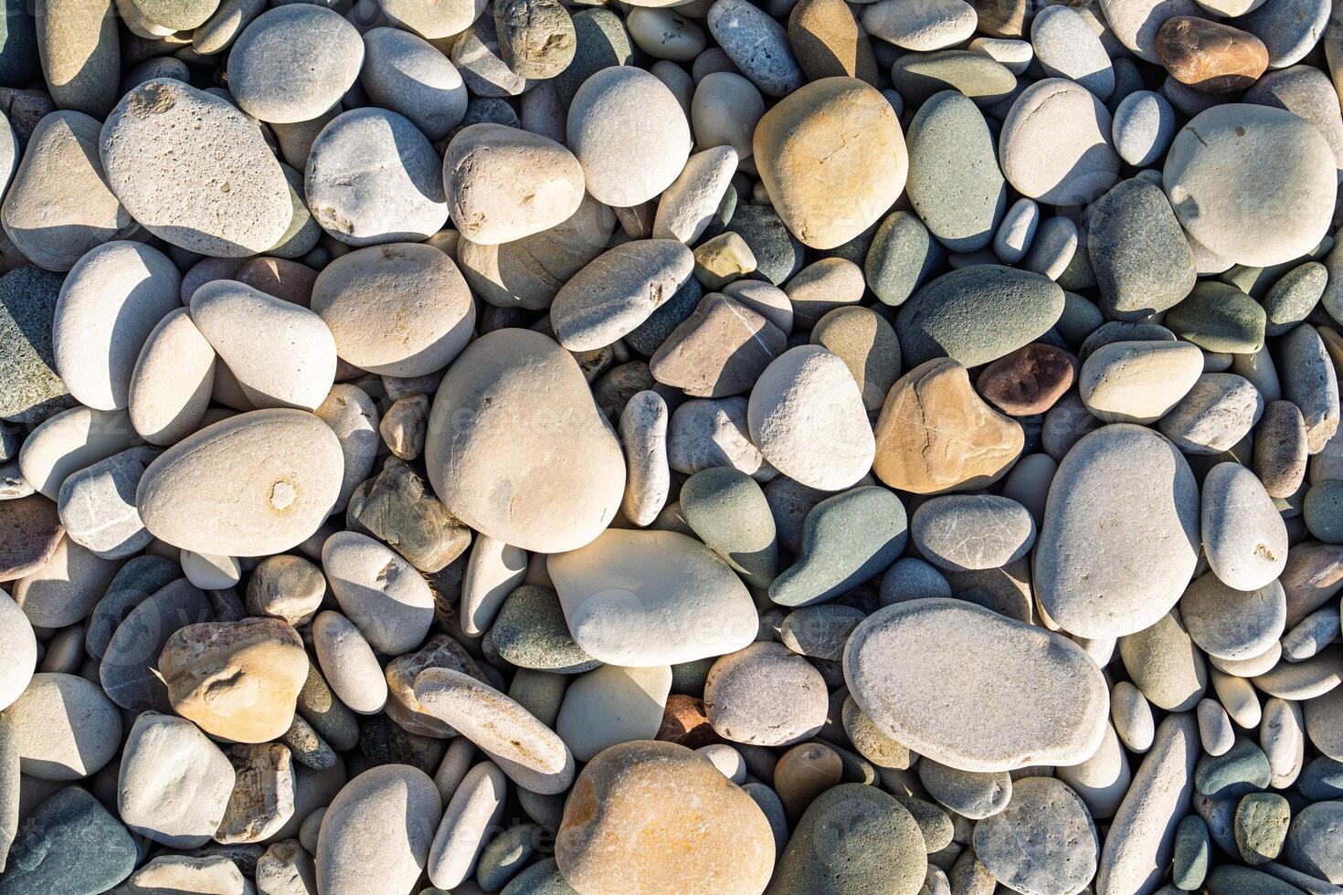 A beautiful collection of smooth beach stones in various sizes and colors. Ideal for backgrounds and designs, these natural pebbles bring tranquility and beauty to any creative project. photo