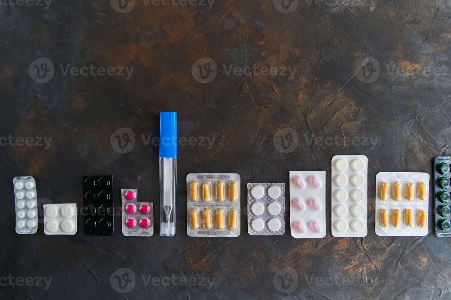 Pills capsules medicine health on dark background, top view photo