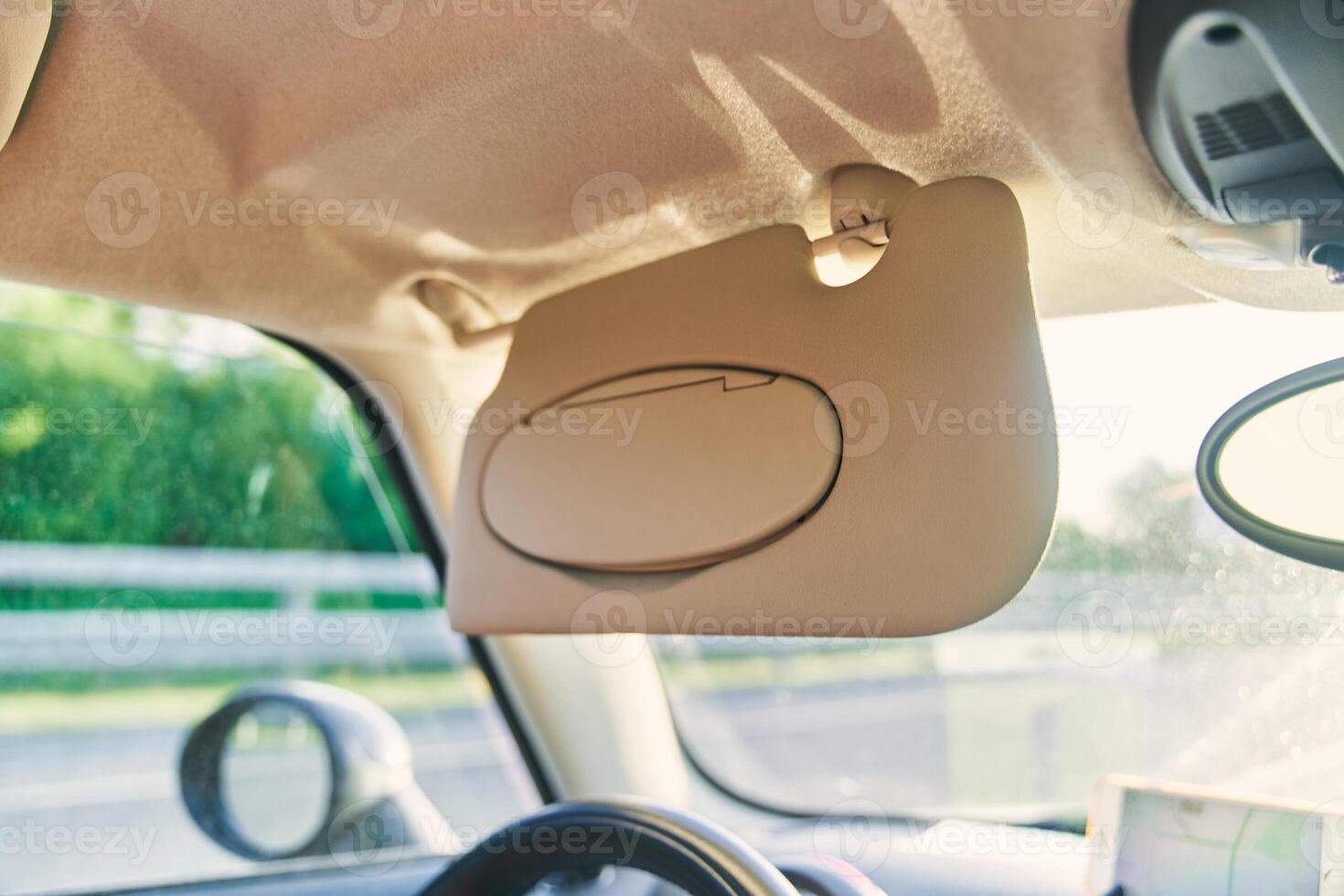 Grey open sun visor in car interior photo
