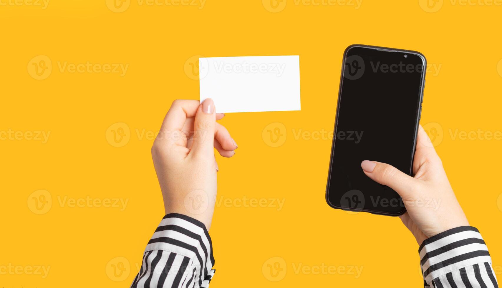 female hand holds a blank business card and a phone. Concept template for mobile application. photo