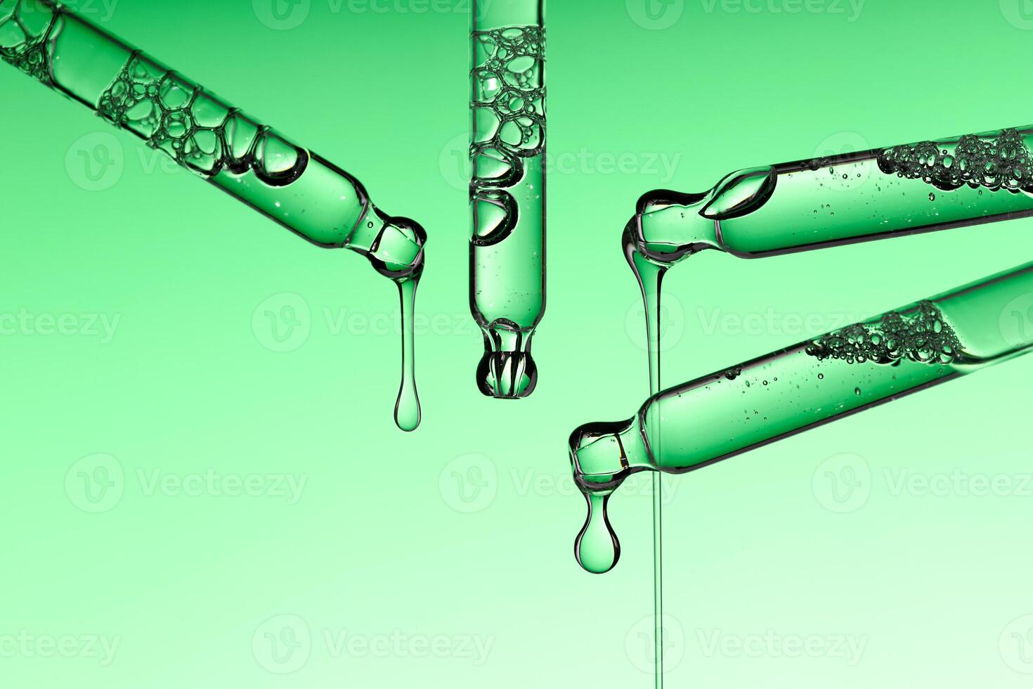 Pipette serum drop with niacinamide hyaluronic or Aha Bha acids on a green isolated background photo