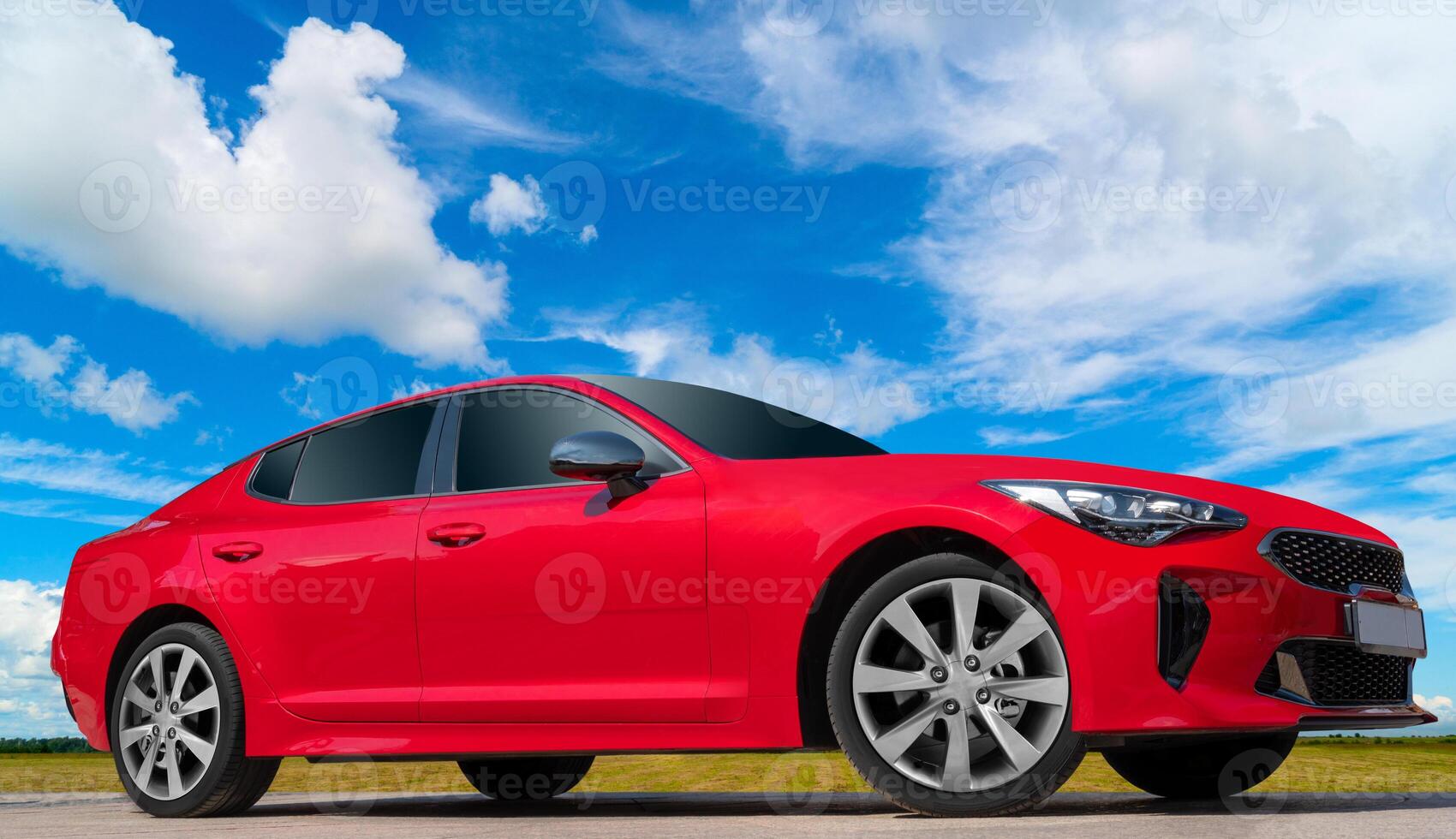 Red car on a blue sky background with white clouds. A bright image of an avto mobile for design solutions. photo