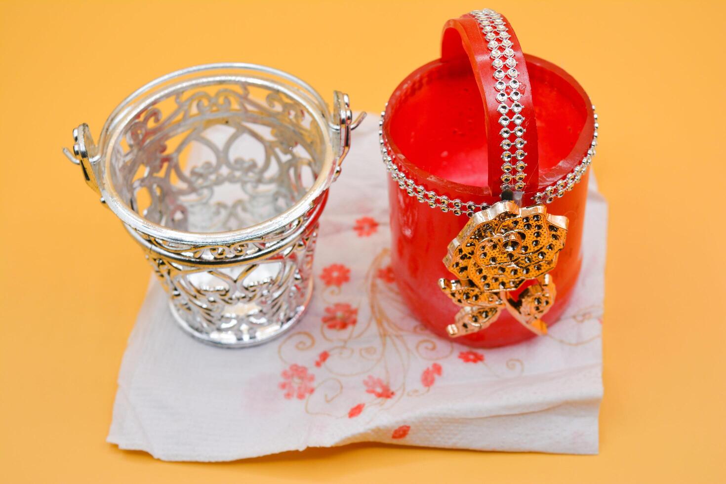 A red and white vase with a silver chain and a silver cup photo