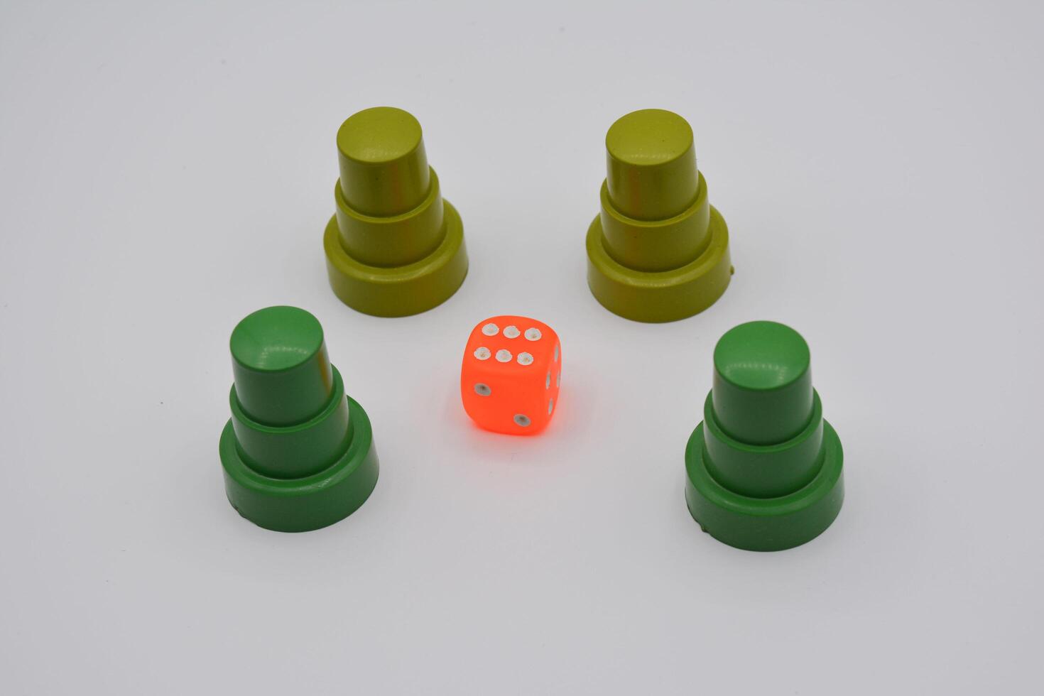Four green plastic dice with one orange one in the middle photo