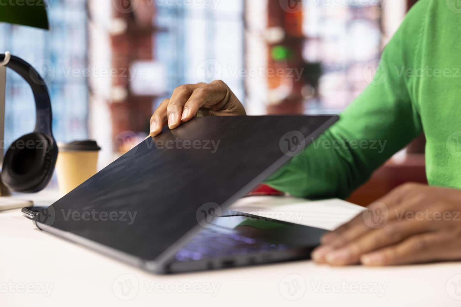 Teleworker at home office desk opening laptop lid to edit documents, updating reports and files. Close up of remote employee starting job shift, opening notebook, managing digital documents photo