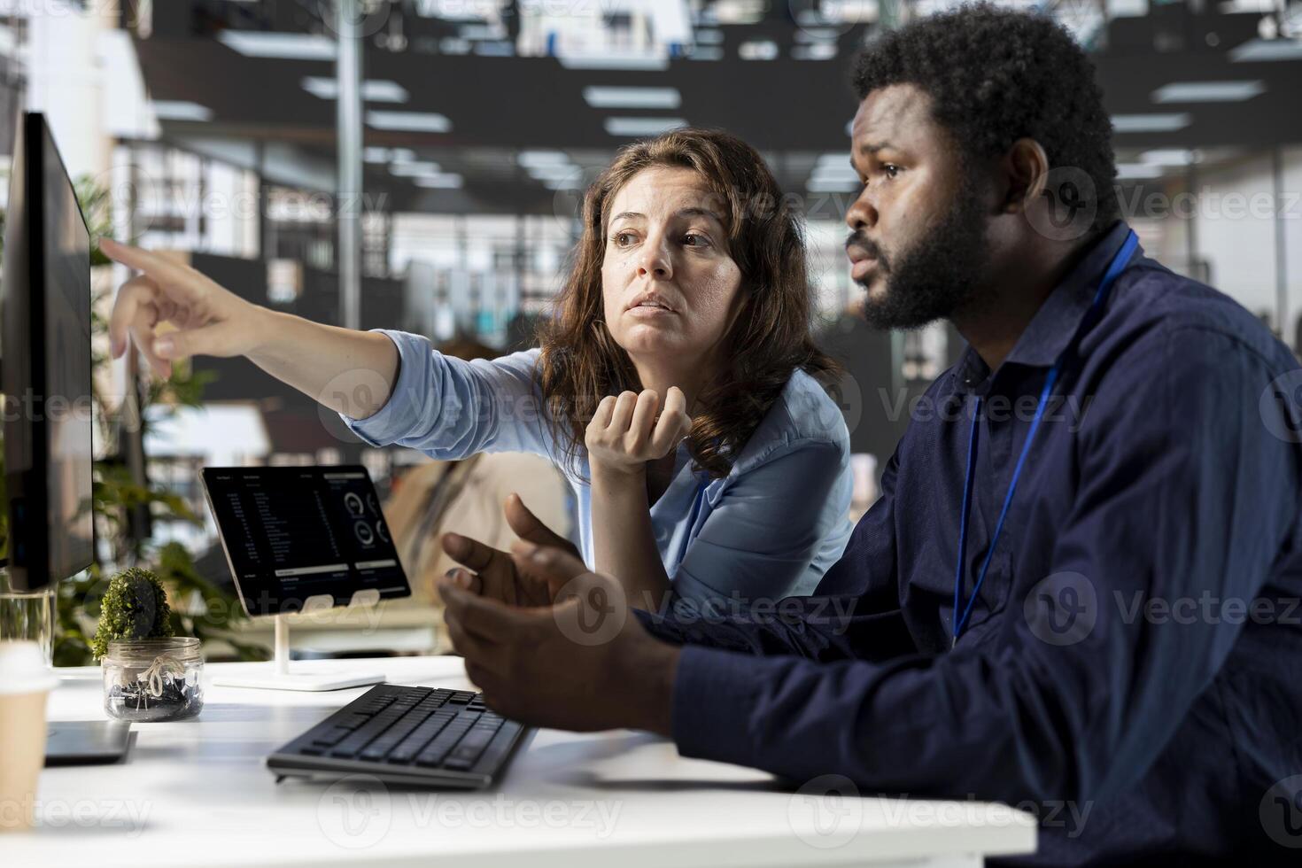 Young employee and manager gathered at the desk to examine data on pc, discussing objectives and strategizing solutions to solve administrative tasks. Aligning business goals and milestones. photo