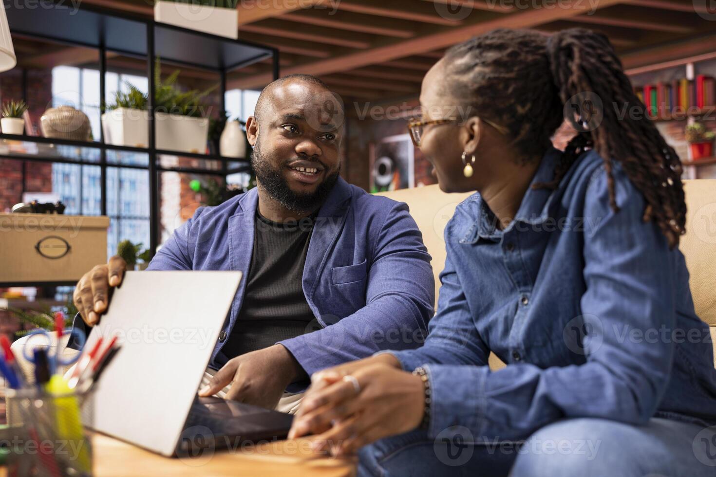 African American man asking his partner to take a break from remote work, sharing a supportive conversation at home. Prioritizing mental health and relaxation to avoid burnout and improve wellbeing. photo
