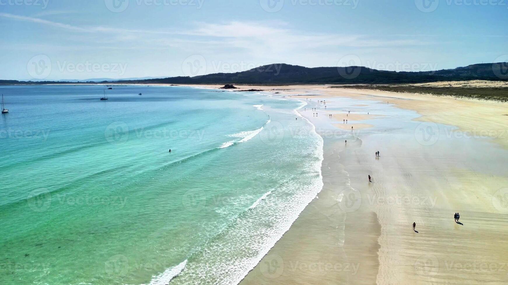 An aerial view showcasing a breathtaking beach where turquoise waters meet golden sands glimmering in the sunlight photo
