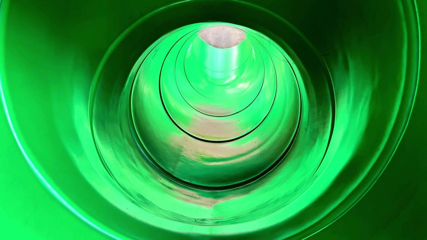 Experience the thrill of a green water slide twisting in lights photo