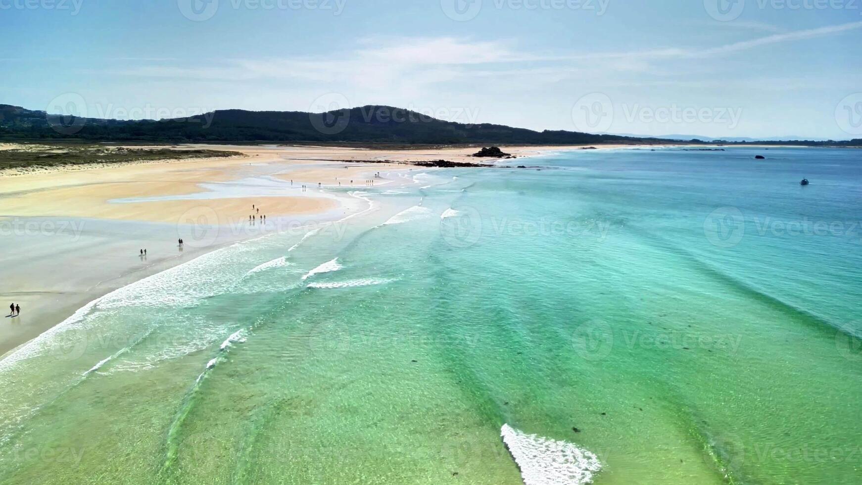 An aerial shot beautifully captures a tranquil beach featuring stunning turquoise water alongside soft, golden sand photo