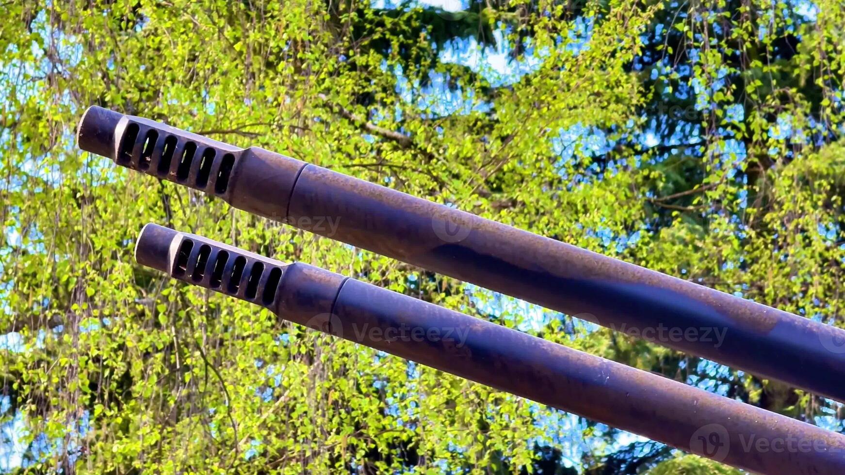 A view of two sleek ducts set against a vibrant green backdrop, highlighting their design and texture intricacies photo
