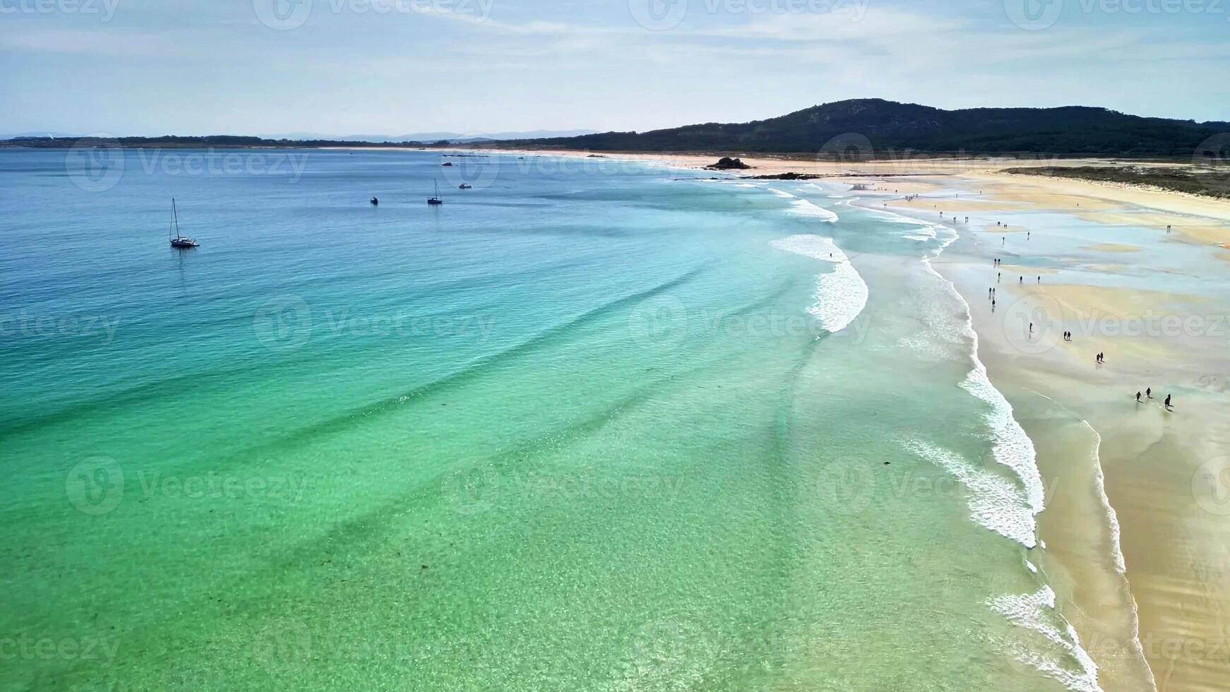 A stunning beach with crystal clear waters and gentle waves, perfect for ultimate relaxation or thrilling adventures photo