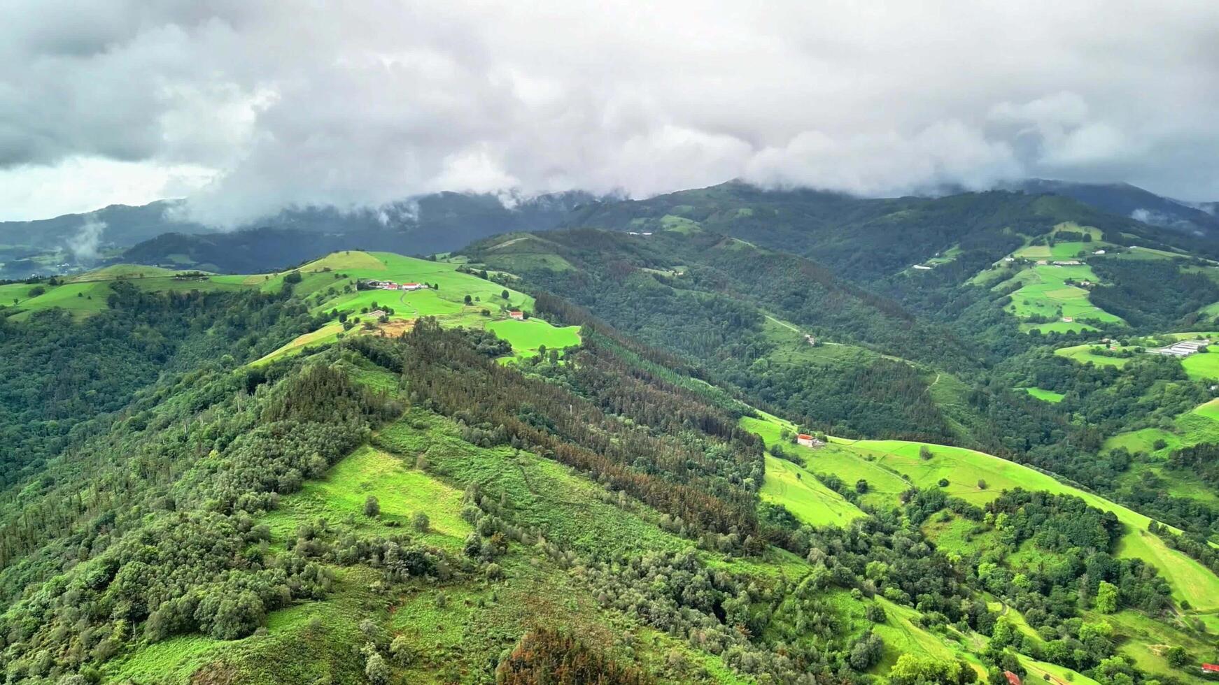 Lush Green Mountains Stretching Under Beautiful, Cloudy Skies A Stunning Aerial Landscape photo