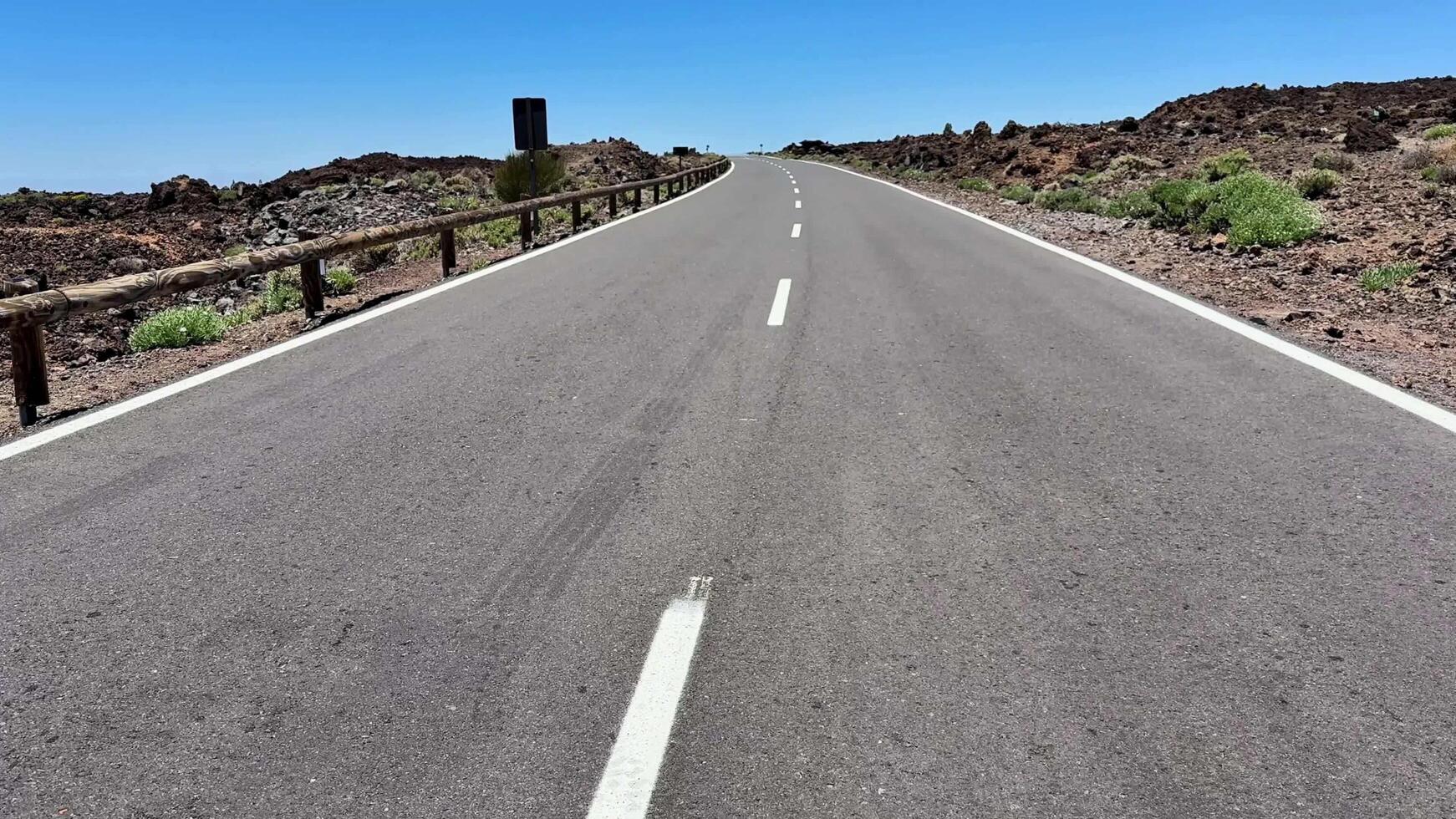 A Scenic Road That Winds Through a Beautiful Volcanic Landscape Beneath Clear Blue Skies photo