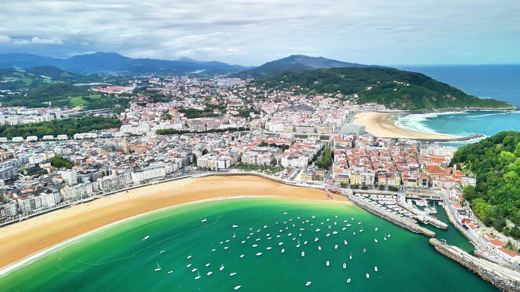 An Aerial View Capturing a Coastal City Featuring a Stunning Beach Alongside a Marina photo