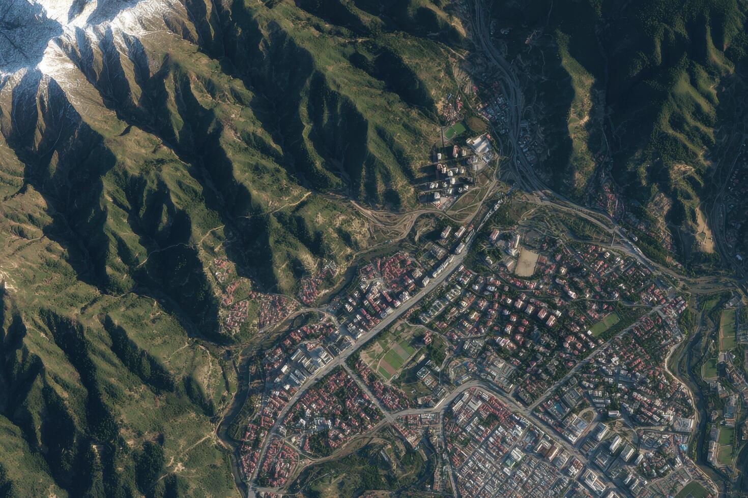 A satellite image of a city surrounded by mountains photo