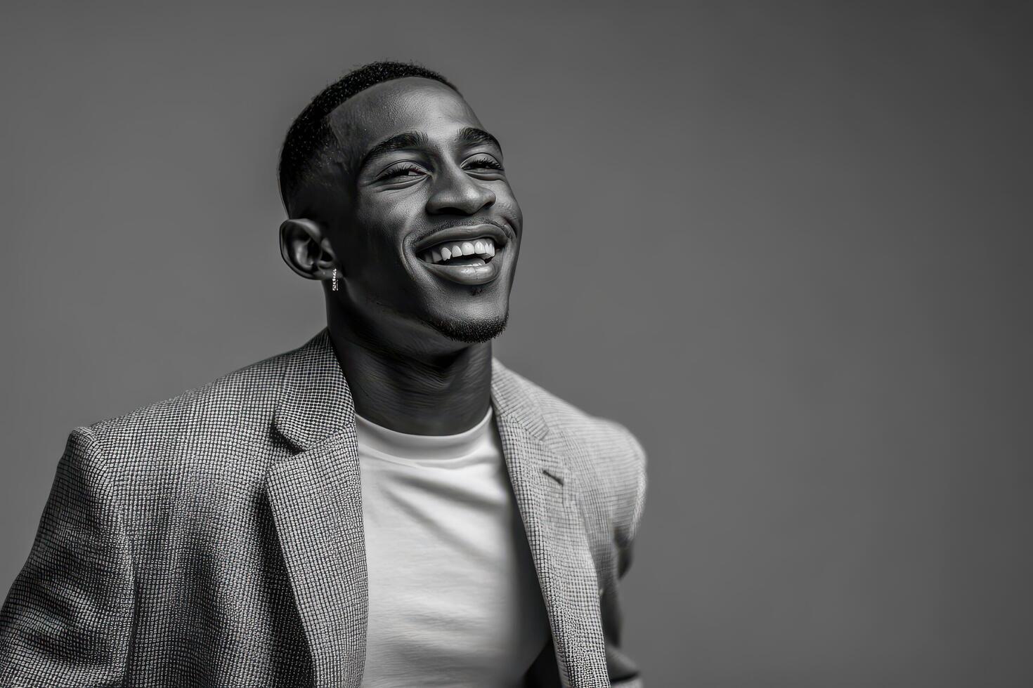 charismatic event host with ultrabright smile stands confidently against clean monochrome wall photo