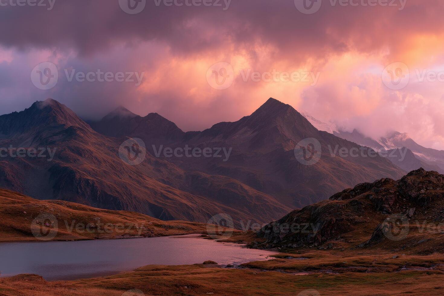 A lake surrounded by mountains at sunset photo
