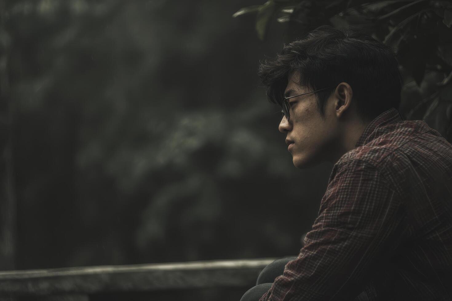 contemplative person sitting in serene environment surrounded by nature reflects on their identity and experiences photo