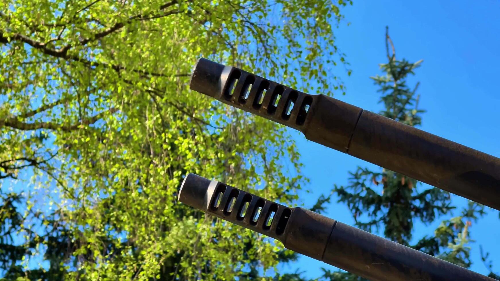 Closeup of a Gun Muzzle against a blue sky, showcasing details of modern firearms precision photo