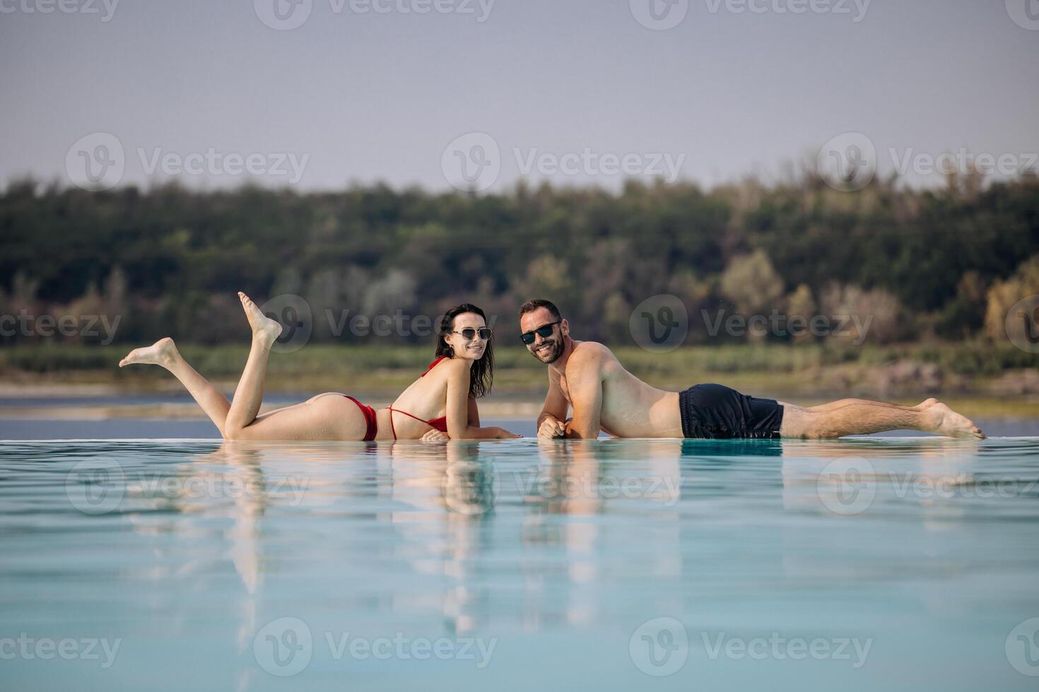 Couple relaxing at infinity pool photo