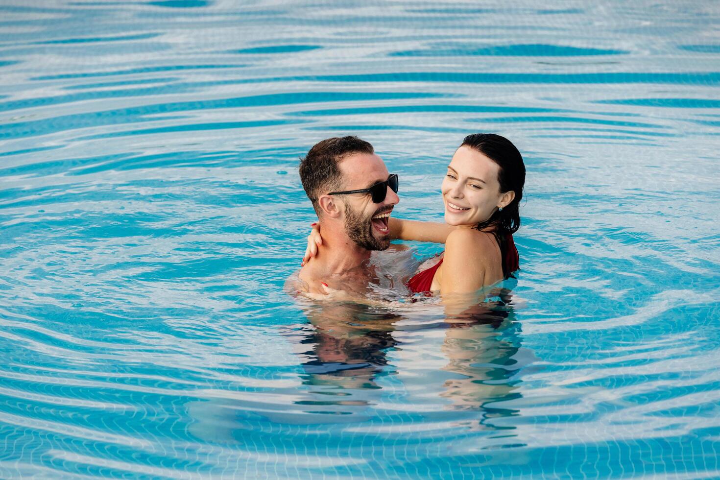 Young couple enjoying a relaxing moment in a pool surrounded by nature. Concept wellness, love. photo