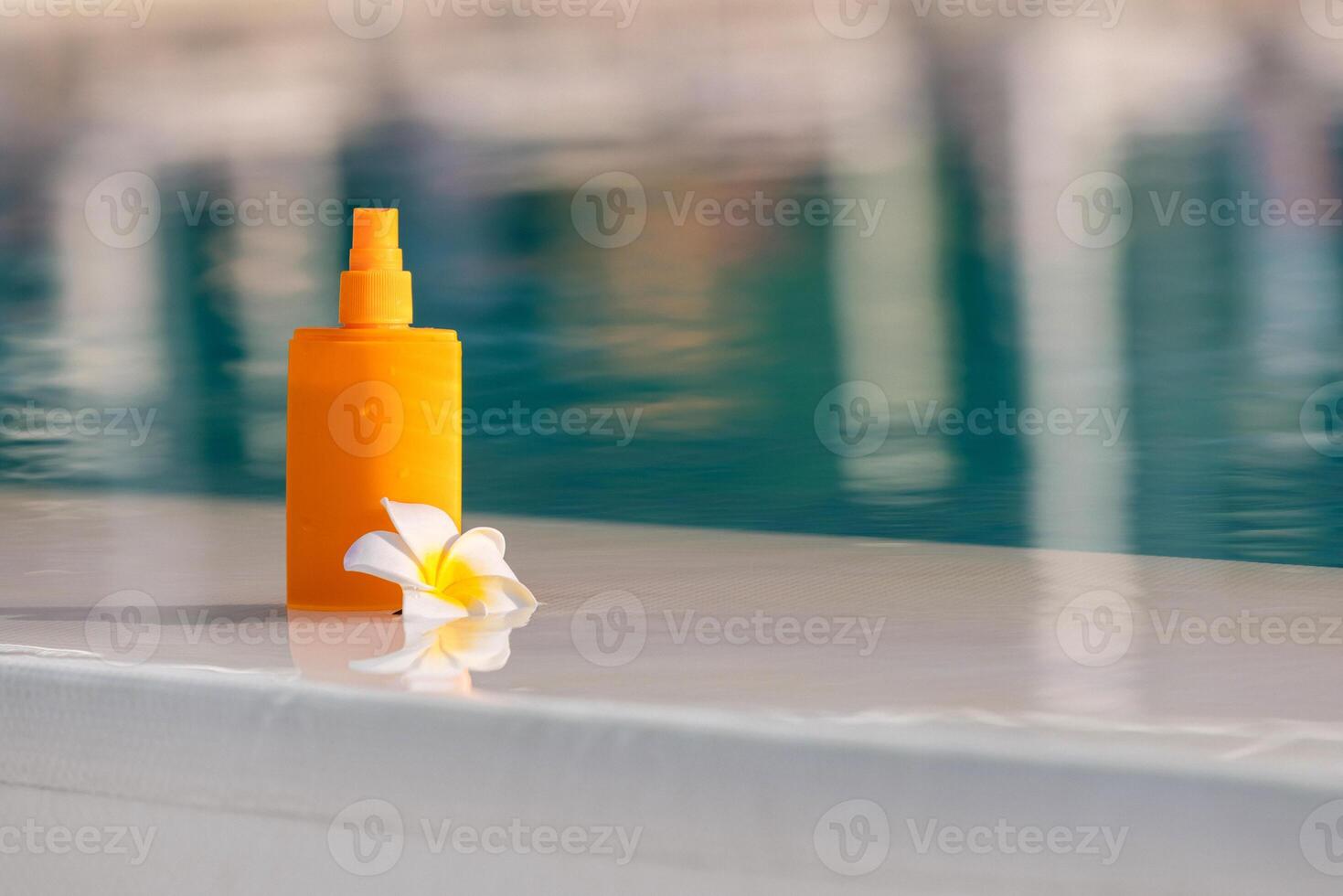 Close-up of a sunscreen spray bottle mockup with a tropical flower nearby. Concept summer skincare and tropical freshness photo