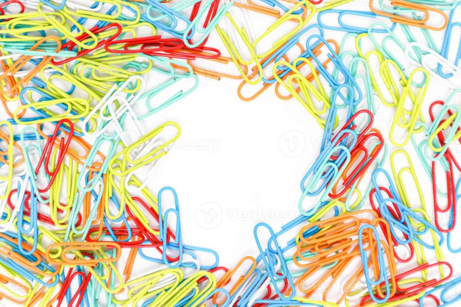 Colorful Paper Clips Arranged Around a White Space, Isolated on White Backdrop for Text Overlay photo