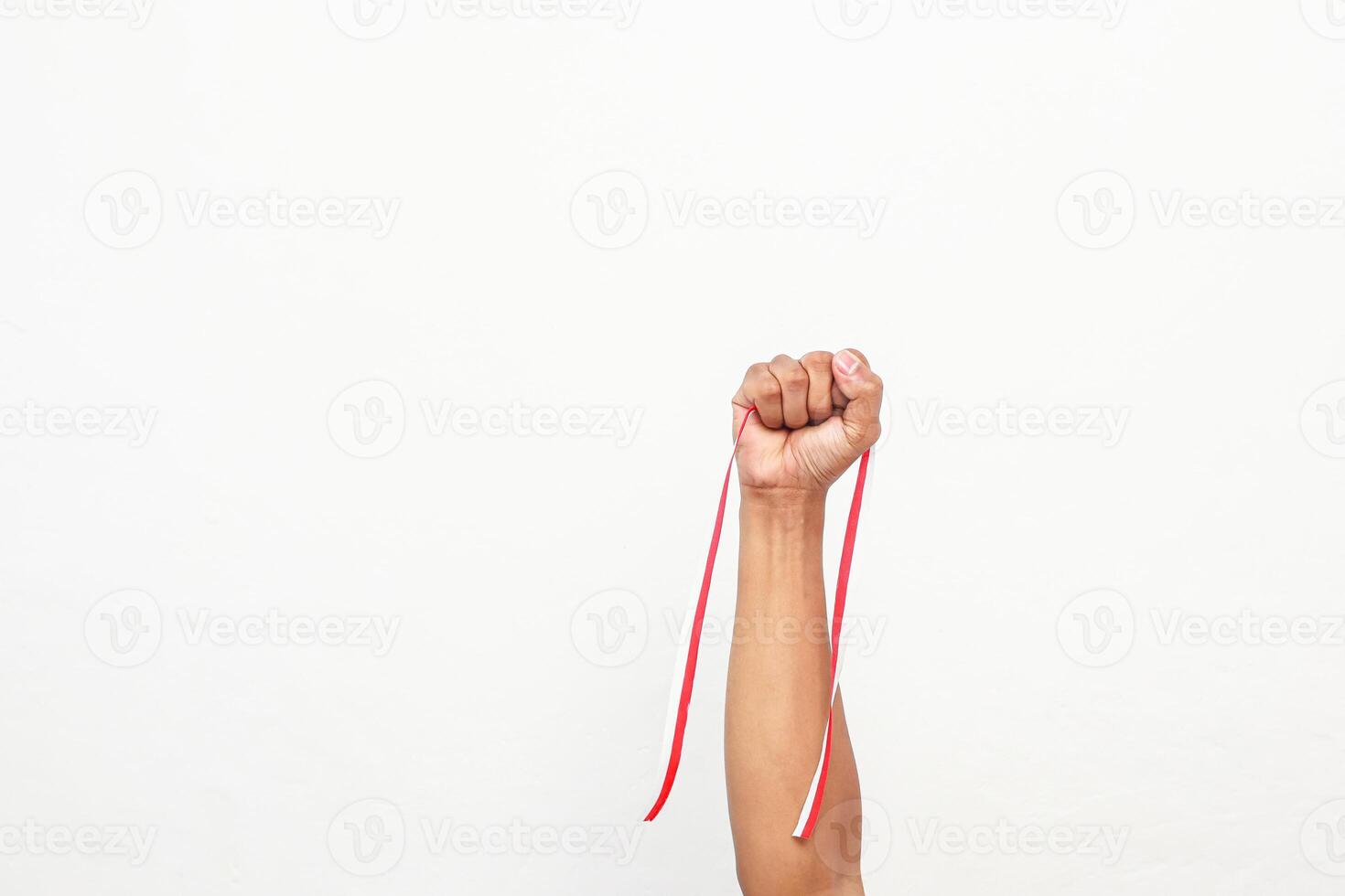 Isolated fist holding a red and white ribbon, symbolising strength and Indonesian Independence Day photo