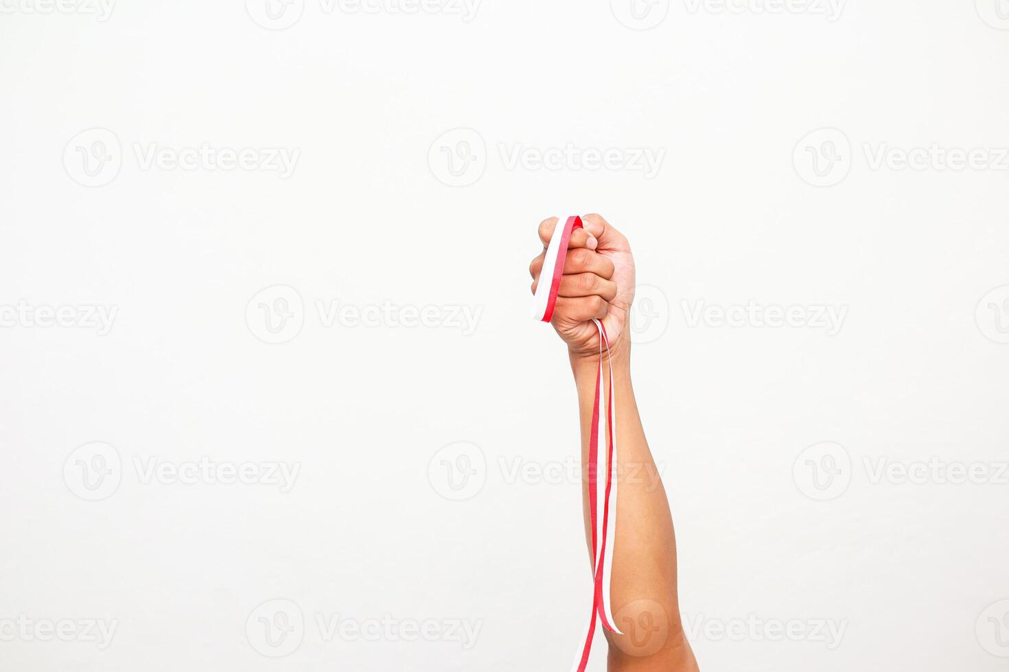 Raised fist holding the Indonesian flag ribbon with patriotic spirit for freedom photo