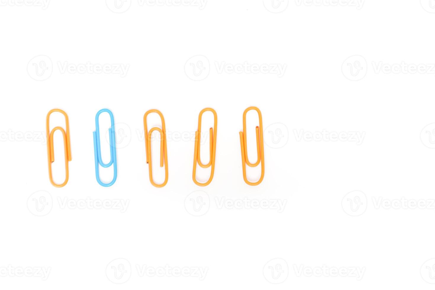 Close-up of colorful paper clips arranged in a row on a clean white background, symbolizing office supplies photo