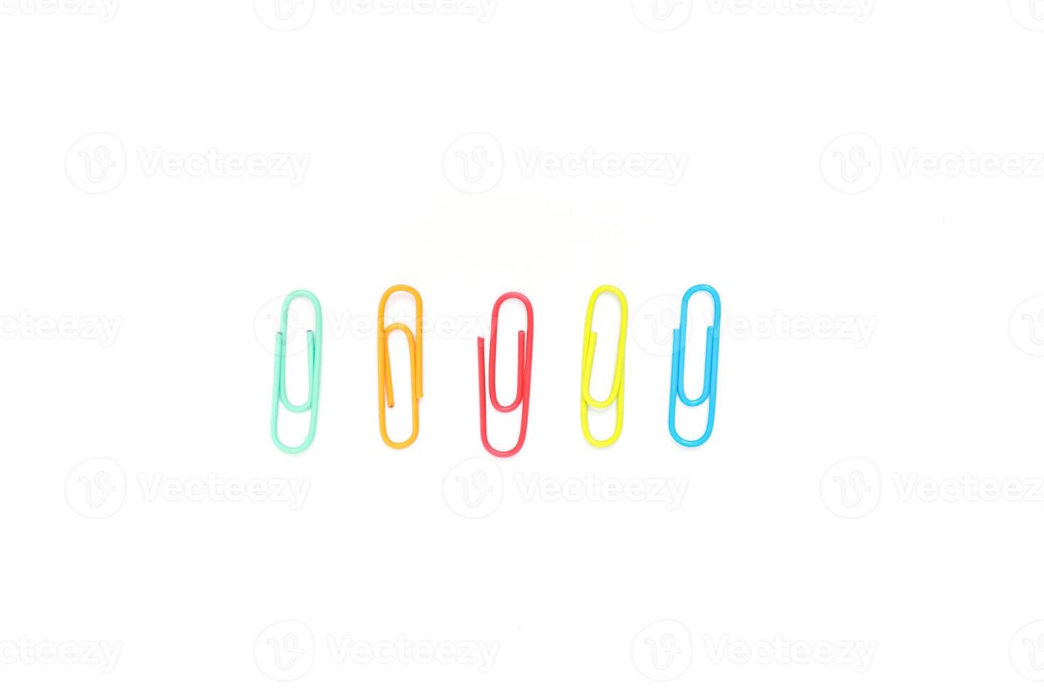 Colorful paper clips on a white background, arranged in a line, office supplies photo
