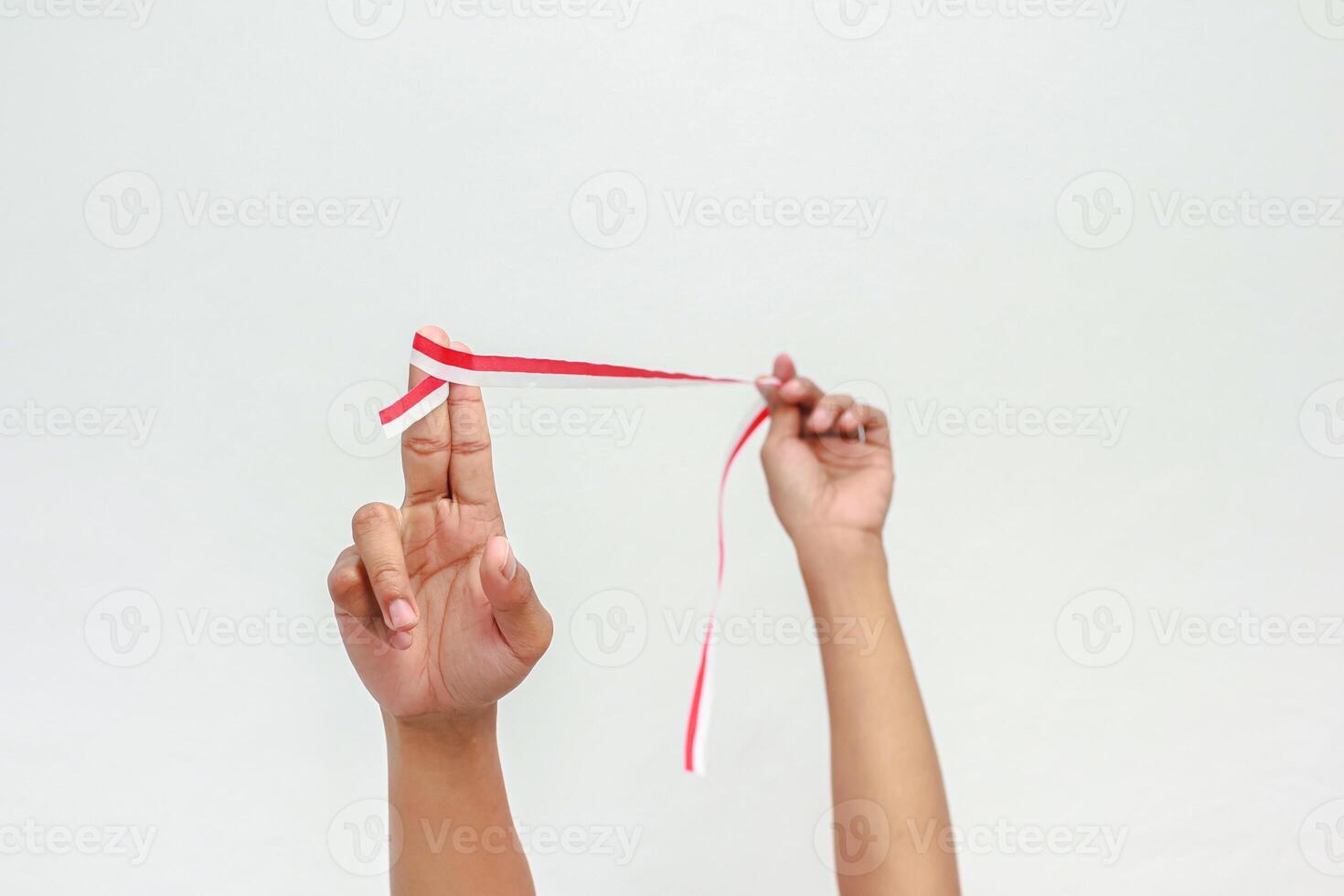 Celebrating Indonesia's Independence Day with a Red and White Ribbon Held by Hand photo