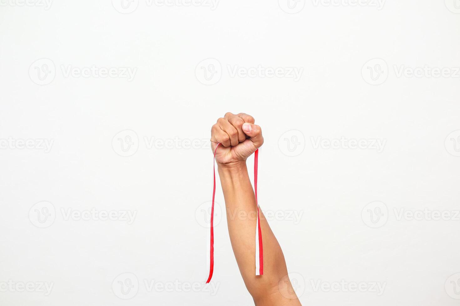 Hand holding a red and white ribbon, a symbol of Indonesian Independence Day photo