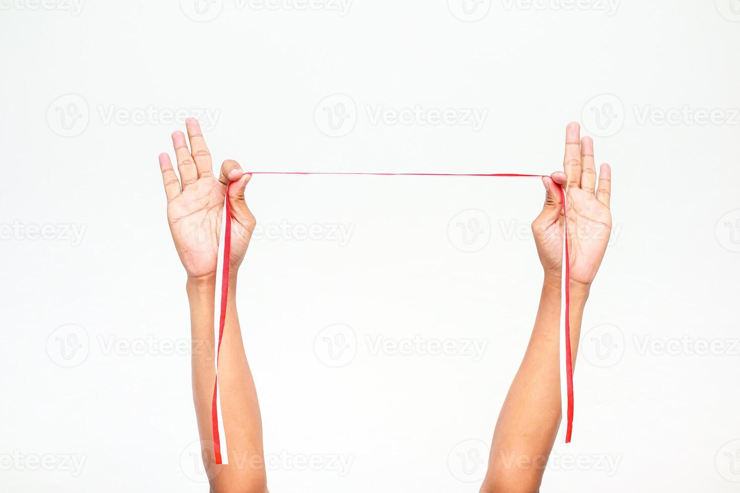 Hands holding a red and white ribbon, symbolising Independence Day for Indonesia or Poland on a plain white background photo